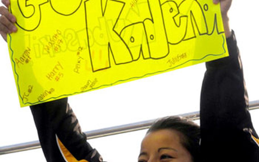 Kadena girls soccer player Chasity Cordova holds a sign in support of her boys counterparts during Friday&#39;s game. Kadena&#39;s boys beat Kubasaki 5-1 and Kadena&#39;s girls also won, 1-0.