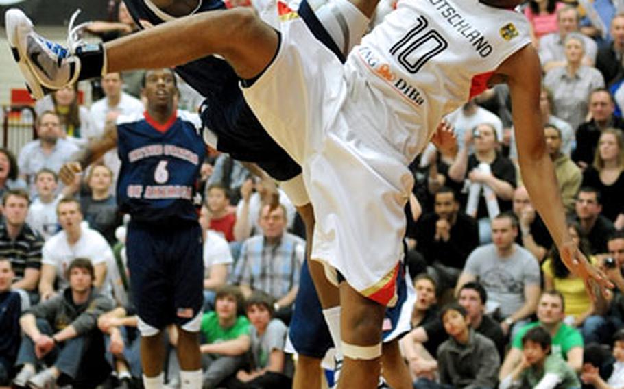 Kevin Ware, left, of the United States is fouled by Bill Borekambi of the German Under-18 team as he drives to the basket in the fourth quarter Friday night. Ware hit the floor hard, and was not able to take the free throws. He later returned to the game.