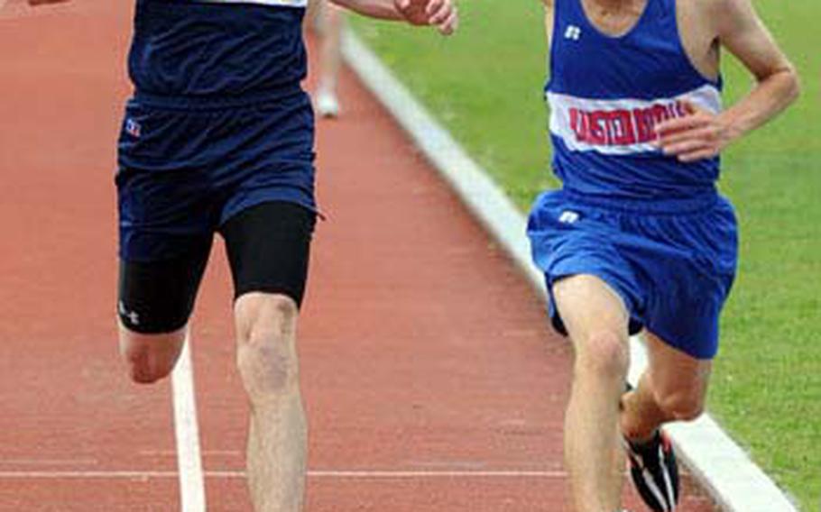 Ramstein’s Carl Lewenhaupt, right, beats Heidelberg’s Jacob Brainerd to the finish line in a close 3,000-meter race. Lewenhaupt won in 9 minutes, 52.12 seconds, with Brainerd crossing in 9:52.52.