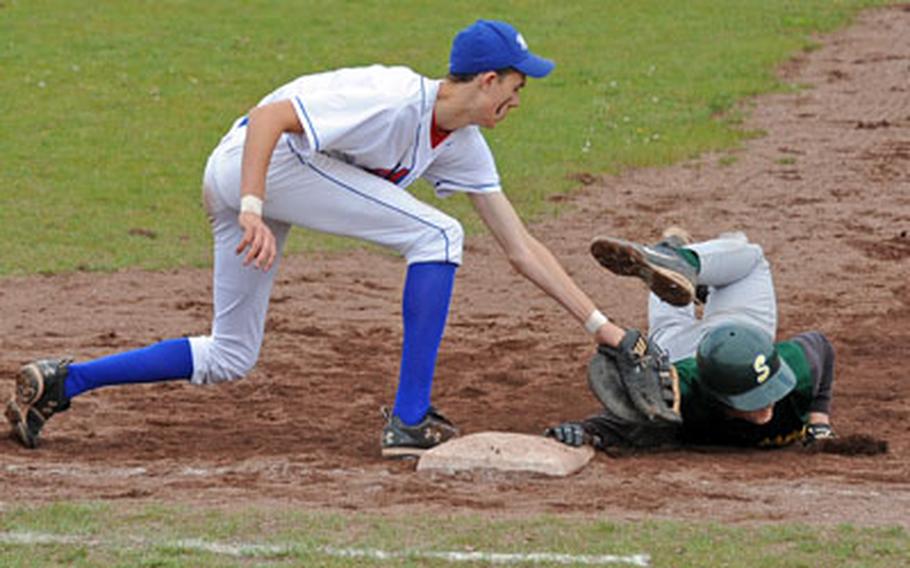 SHAPE&#39;s Mitchell Goff, right, gets his hand on the bag before Ramstein&#39;s Tyler Breed can put the tag on him in a pick-off attempt at first. Ramstein won the first game of a doubleheader in Ramstein on Saturday, 8-5.