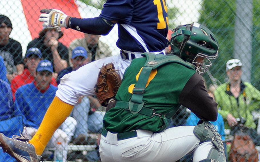 Heidelberg third baseman Jimmy Montfleury scores as SHAPE catcher Mitchell Goff drops the ball during opening-day action in the DODDS-Europe Division I baseball tournament. SHAPE won 7-3.