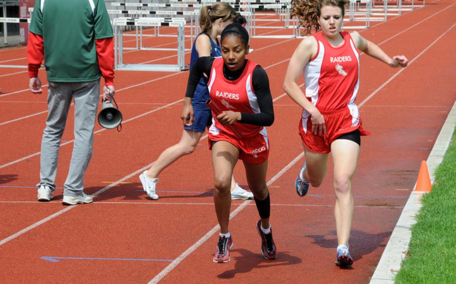 Kaiserlautern's Rio Shaune Harris hands the baton to Marche' Bobbs for the final leg of the girls 4x800-meter relay, won by Kaiserslautern in 9 minutes, 58.43 seconds on the first day of the DODDS-Europe Track and Field Championships at the Rüsselsheim, Germany, stadium. Vilseck finished second in 10:28.43, followed by Heidelberg in 10:31.56.