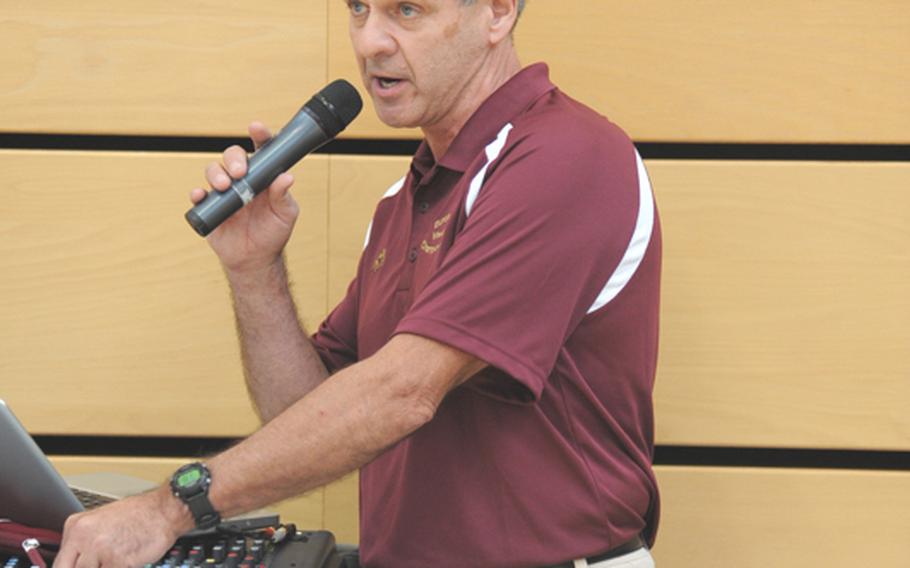 Tom Richards adjusts the volume while making an announcement at February&#39;s DODDS-Europe wrestling championship. The tournament was one of the last during which he served as the announcer. He retires this month after working with DODDS-Europe since 1977.