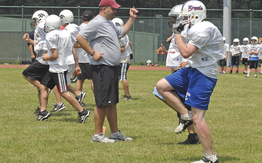 Marty Costello, a coach at Valley City State University in North Dakota, makes sure participants at the football camp in Miesau, Germany, warm up correctly before the contact begins on Thursday afternoon.