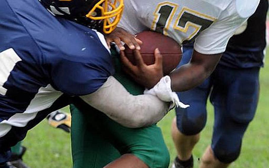 Joint Task Force Wolfpack quarterback Mike Geddie (17) gets dragged down by Yokota Warriors defender Eric Woodcox during Saturday's U.S. Forces Japan-American Football League Torii Bowl championship game at Bonk Field, Yokota High School, Yokota Air Base, Japan. Yokota won 26-23.