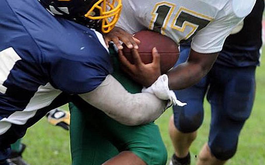 Joint Task Force Wolfpack quarterback Mike Geddie (17) gets dragged down by Yokota Warriors defender Eric Woodcox during Saturday&#39;s U.S. Forces Japan-American Football League Torii Bowl championship game at Bonk Field, Yokota High School, Yokota Air Base, Japan. Yokota won 26-23.