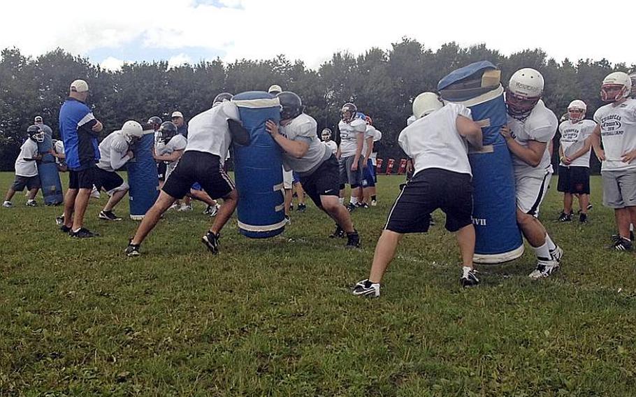 Linemen batter the blocking dummies during a drill at the DODDS-Europe football West Camp in Bitburg, Germany, on Wednesday.