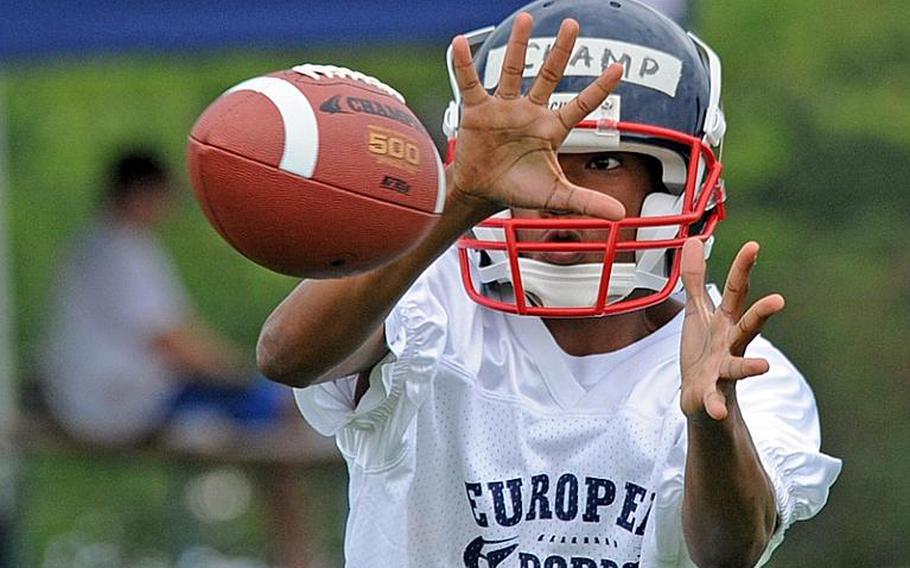 Brian Champ, who will be a freshman at Lakenheath, keeps his eyes on the ball as he pulls in a pass at the DODDS-Europe football West Camp in Bitburg, Germany, on Wednesday.