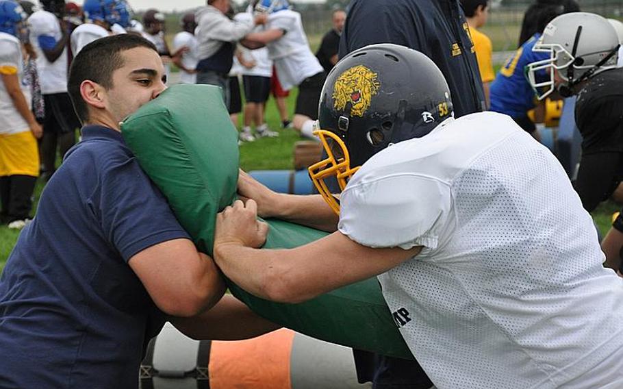 Frank Moya, a coach from the Ansbach football team, takes on Heidelberg freshman Joshua Luna during a lineman training drill Wednesday at the the DODDS-Europe football camp in Ansbach, Germany.