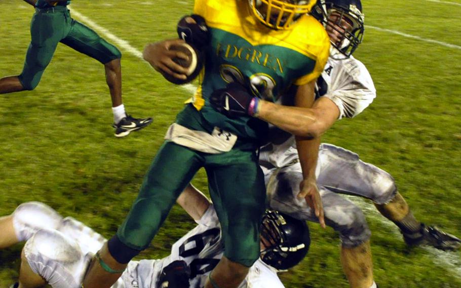 Robert D. Edgren Eagles receiver Xavier Major is wrestled down by two Zama American Trojans defenders during Friday&#39;s DODDS Japan high school football game at Eagles Field, Robert D. Edgren High School, Misawa Air Base, Japan. Defending DODDS Japan and Far East Division II champion Zama beat Edgren 42-22.