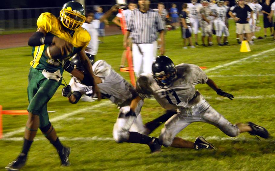 Robert D. Edgren Eagles receiver Xavier Major hustles past two Zama American Trojans defenders into the end zone for one of his two touchdowns during Friday&#39;s DODDS Japan high school football game at Eagles Field, Robert D. Edgren High School, Misawa Air Base, Japan. Defending DODDS Japan and Far East Division II champion Zama beat Edgren 42-22.