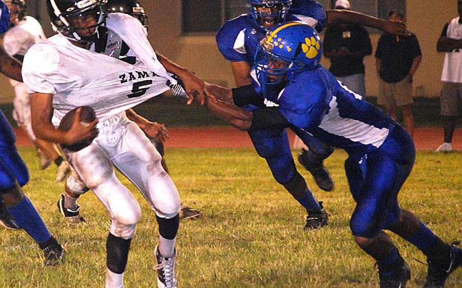 D.J. Ward of Zama American is tackled on a flea flicker play by Yokota defender Stanley Speed during Friday&#39;s DODDS Japan/Kanto Plain Association of Secondary Schools football game at Bonk Field, Yokota High School, Yokota Air Base, Japan. Yokota won 17-0.