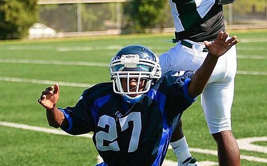 Jalah Patten of Kubasaki snags a pass over Seoul American&#39;s Brandy Holmes (27) during Saturday&#39;s interarea high school football game at Sims Field, Seoul American High School, South Post, Yongsan Garrison, South Korea. Kubasaki won 31-6.