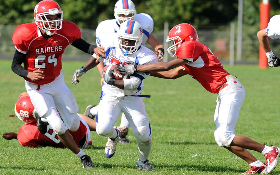 Ramstein's Caleb Guerrido, center, breaks away from Kaiserslautern's Bernard Burwell, left, and Robert Grant for a big gain in Ramstein's 23-7 win over the Raiders in Kaiserslautern on Saturday.