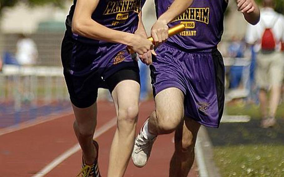Mannheim&#39;s Adam Cornelius takes the baton  from Richard Walker during the boys 3,200 meter relay at a track meet in Mannheim on Saturday. Mannheim won the event.