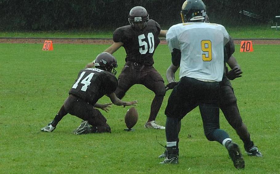 Vilseck place-kicker Keenan Massey attempts a field goal Saturday as the rain pours down in the second quarter. The attempt was blocked as Heidelberg went on to win 14-0 and take first place of Division I-South.
