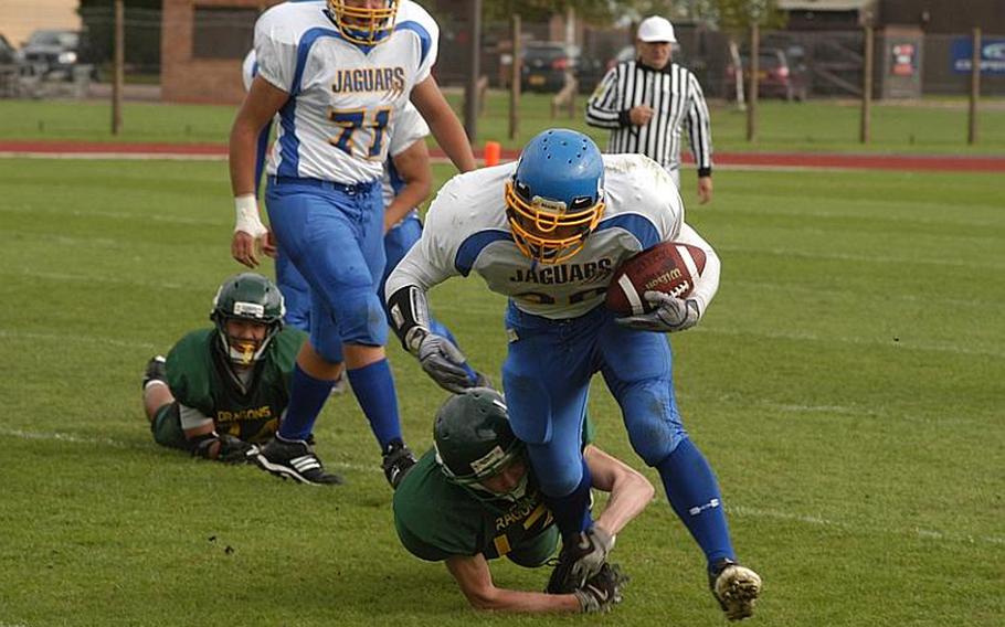 Sigonella running back Jeff Lastrella sheds a tackle attempt by linebacker Beau Hocevar on his way to a first down. Lastrella totaled 89 rushing yards in the game, won by Alconbury, 26-20, in double overtime.