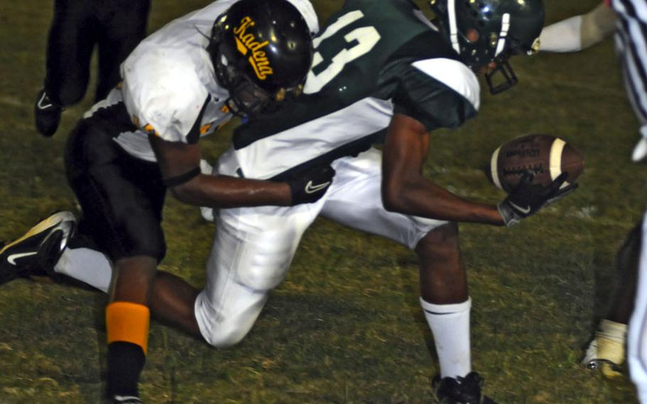 Kubasaki receiver Columbus Wilson has trouble gripping the ball as he's tackled by Kadena's Moises Charles during Friday's Okinawa Activities Council football game at Mike Petty Stadium, Kubasaki High School, Camp Foster, Okinawa. Kadena routed Kubasaki, 56-16.