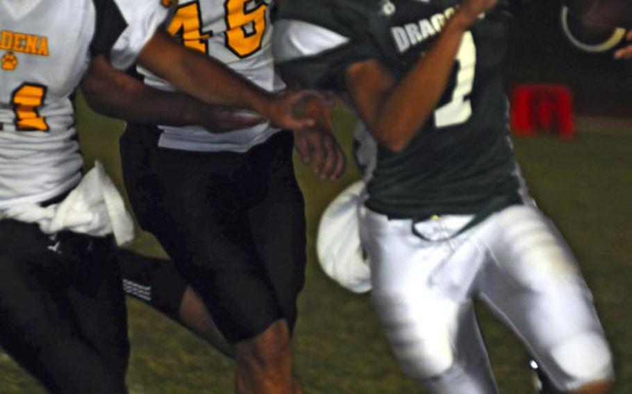 Kubasaki quarterback Cristian Rivera is chased down by Kadena defenders Cory Peckins, left, and Aaron Ahner during Friday's Okinawa Activities Council football game at Mike Petty Stadium, Kubasaki High School, Camp Foster, Okinawa. Kadena routed Kubasaki, 56-16.