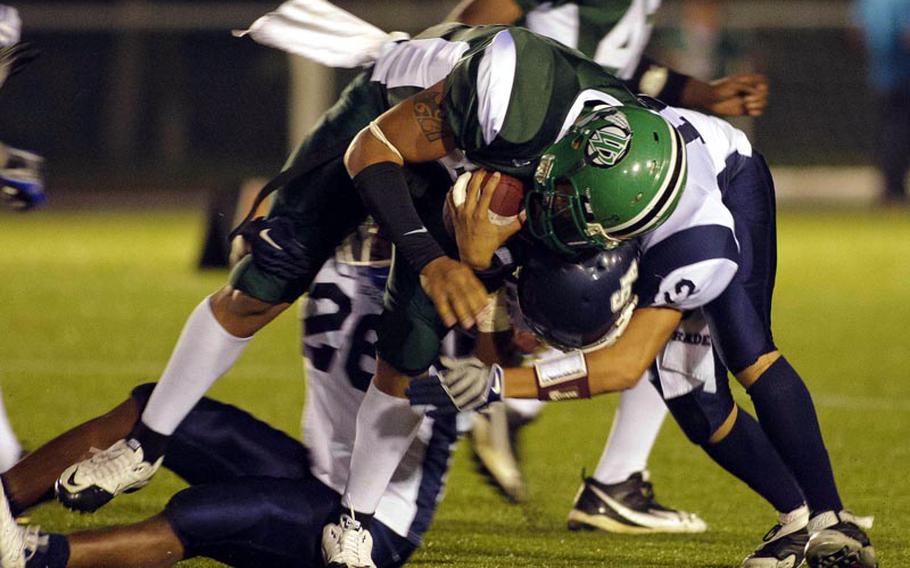 Daegu American quarterback Tre Griffin gets knocked down by Seoul American's Harold Martin during Friday's DODDS Korea football game at Kelly Field, Camp Walker, South Korea. Daegu routed Seoul, 40-14.