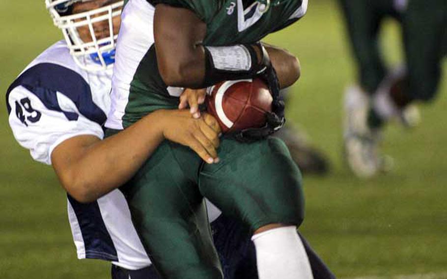 Daegu American's Jacobi Myles tries to hold onto the ball as he's tackled by Seoul American's Sidney Malauulu during Friday's DODDS Korea football game at Kelly Field, Camp Walker, South Korea. Daegu routed Seoul, 40-14.