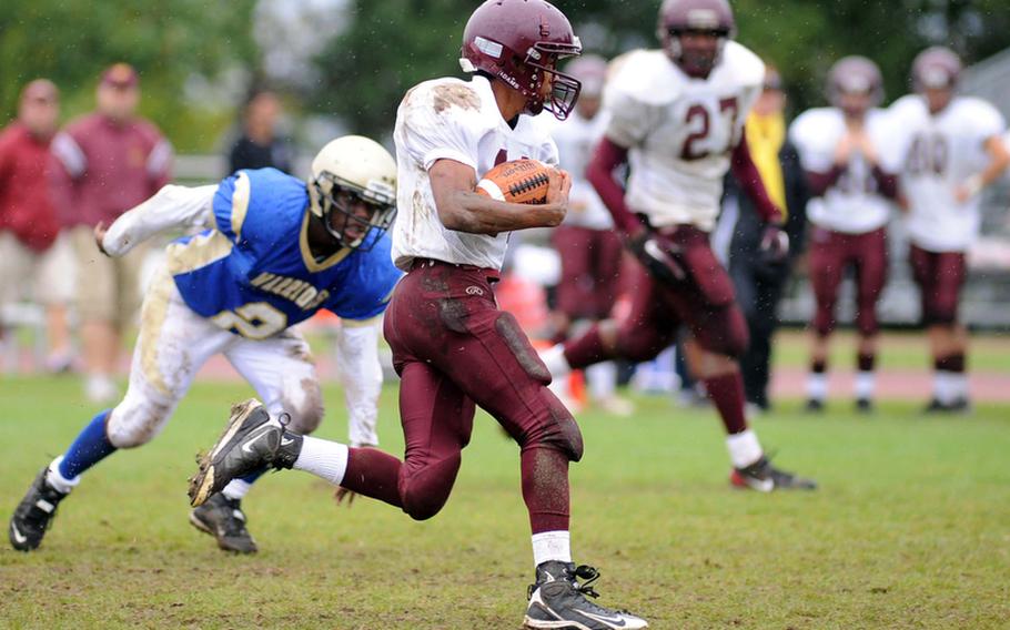 Vilseck's Damon Ellison eludes Wiesbaden's Jamichael Wiley on his way to scoring the Falcons' only touchdown in their 34-7 loss to Wiesbaden, in Wiesbaden, on Saturday. Kalyn Smithson watches in the background.