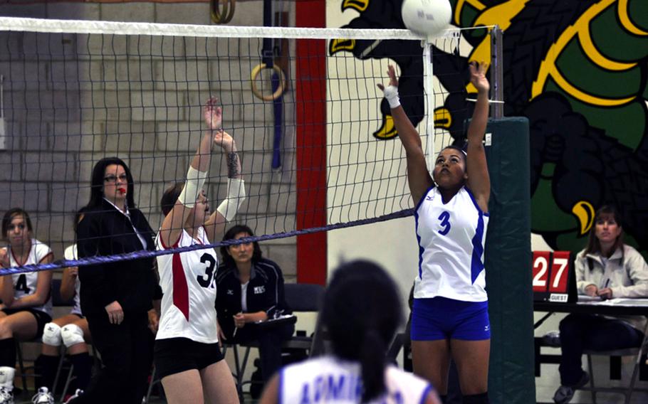 Rota Admiral player Yosenia Solis sets the volleyball during a match against the Menwith Hill Mustangs. Mustang player Sarah Hoover maneuvers her way into a better defensive position.
