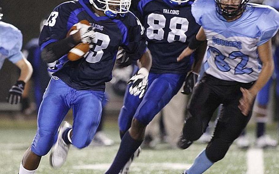Seoul American's Antoine Daniels gets an escort from Falcons teammate Tommy Akinbayo as Osan American's Cody Florence gives chase during Friday's DODDS Korea high school football game at Sims Field, Seoul American High School, South Post, Yongsan Garrison, South Korea. The Falcons won their first game of the season, 41-6, over the Cougars.