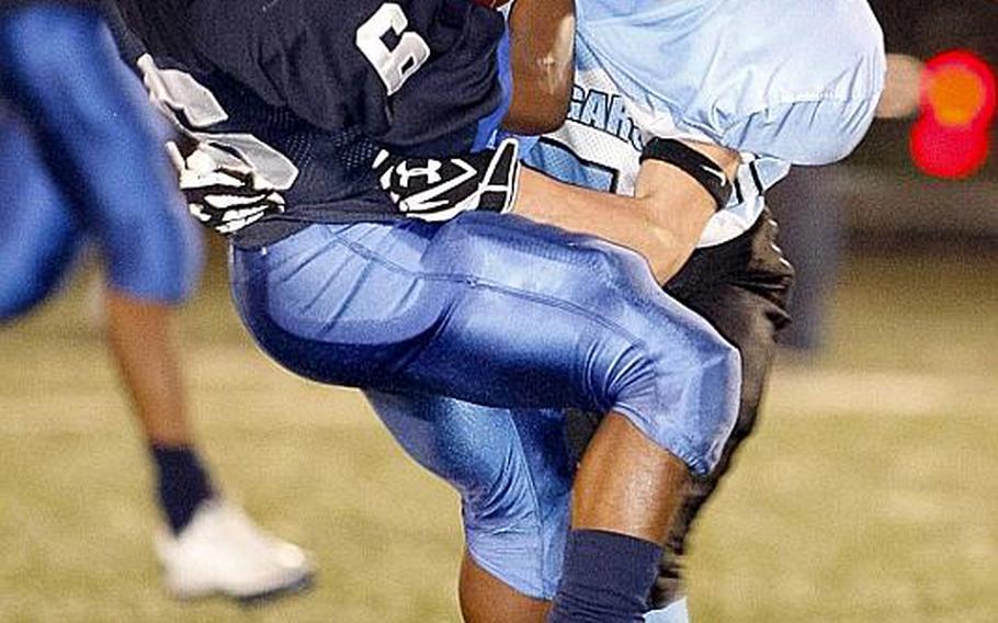 Seoul American's Corey Robinson collides with Osan American's Brett Hammontree as he catches the ball during Friday's DODDS Korea high school football game at Sims Field, Seoul American High School, South Post, Yongsan Garrison, South Korea. The Falcons won their first game of the season, 41-6, over the Cougars.