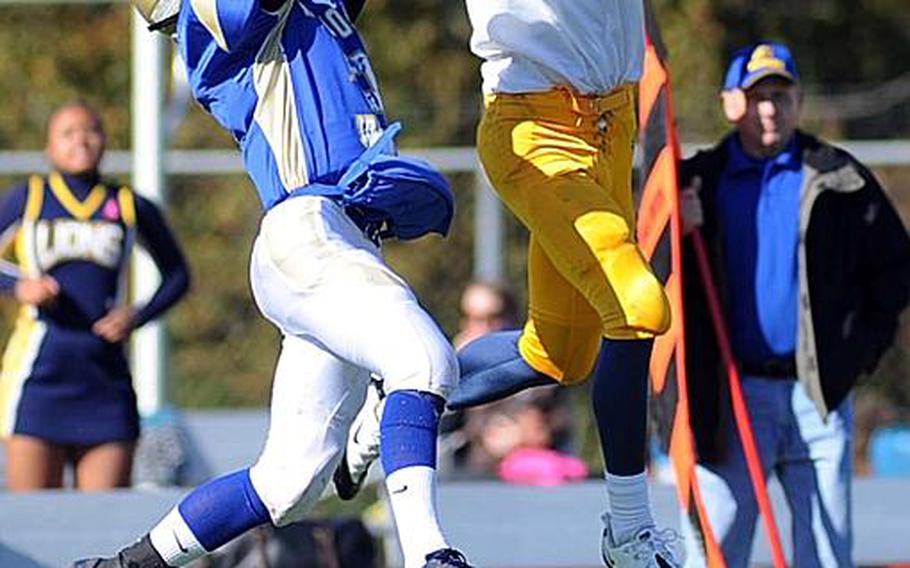 Heidelberg's Chase Boone, right, pulls in a pass in front of Wiesbaden's Drew Polson in a Division I game in Wiesbaden, on Saturday. Hoke's run following the reception set up a Heidelberg touchdown. The Lions defeated Wiesbaden, 54-19, with the clock running much of the fourth quarter.