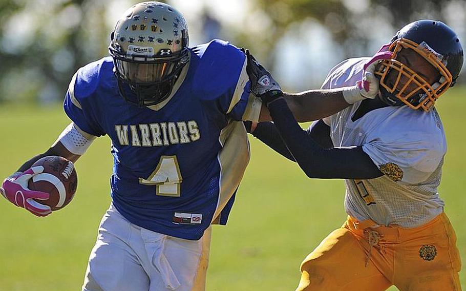 Wiesbaden&#39;s Daniel Harris keeps Heidelberg defender Sterling Jones at arm&#39;s  length as he picks up yardage in the Division I game in Wiesbaden, on Saturday. His efforts were for naught, as the Lions beat Wiesbaden 54-19, with the clock running much of the fourth quarter.
