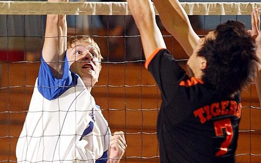 Greg Morris of Seoul American, left, smacks a spike into the block of Seoul International's Albert Lee during Wednesday's Korean-American Interscholastic Activities Conference boys Division I volleyball match at Falcon Gym, Seoul American High School, South Post, Yongsan Garrison, South Korea. The Falcons swept the Tigers 25-16, 25-19, 28-26.