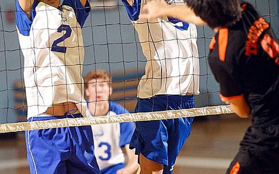 Seoul International's Jay Chung slams a spike as Seoul American's Josh Chung, left, and Jason Liu try to block during Wednesday's Korean-American Interscholastic Activities Conference boys Division I volleyball match at Falcon Gym, Seoul American High School, South Post, Yongsan Garrison, South Korea. The Falcons swept the Tigers 25-16, 25-19, 28-26.