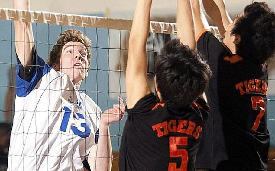 Seoul American's Colton Heckerl readies a spike as Sean Vanzo. center, and Albert Lee of Seoul International go up to block during Wednesday's Korean-American Interscholastic Activities Conference boys Division I volleyball match at Falcon Gym, Seoul American High School, South Post, Yongsan Garrison, South Korea. The Falcons swept the Tigers 25-16, 25-19, 28-26.