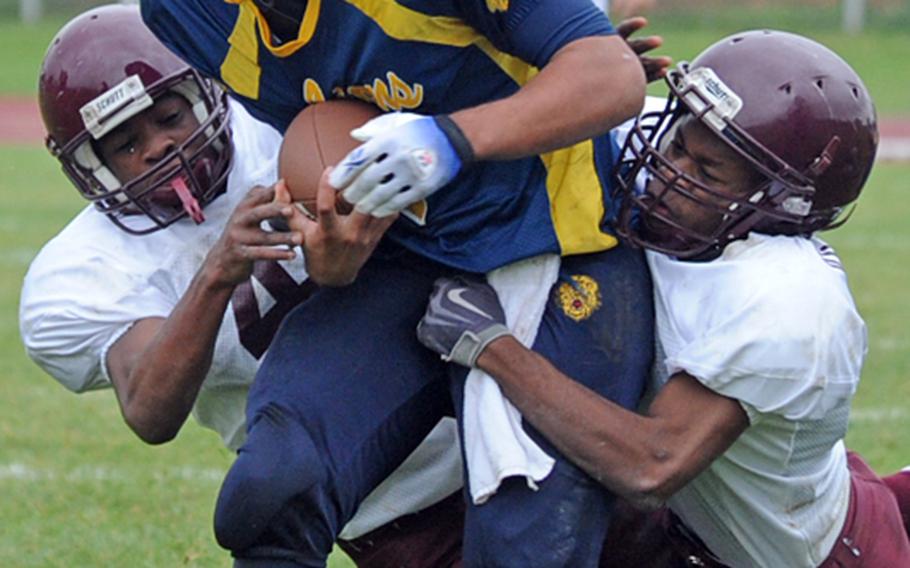 Vilseck's Dennis Thomas, left, and Xavier Scott try to drag down Heidelberg's Chris Cuthbert in a Division I game in Heidelberg, on Saturday. Heidelberg won its homecoming game 34-6.
