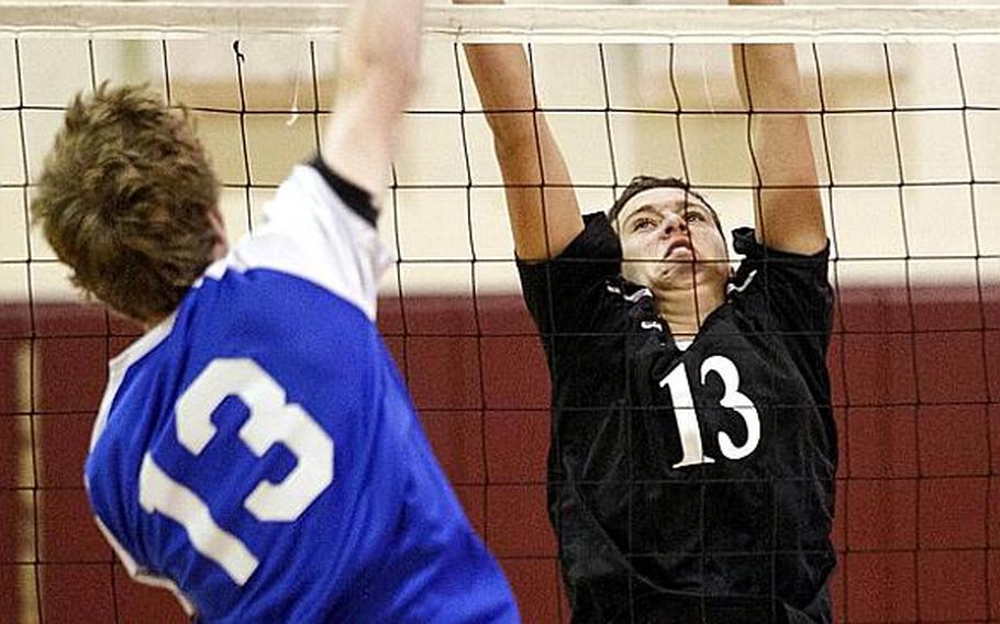 Seoul American's Colton Heckerl tries to spike through the block of Osan American's Brandon Gerbozy during Friday's Korean-American Interscholastic Activities Conference boys volleyball match at Cougars Gymnasium, Osan American High School, Osan Air Base, South Korea. Osan won 25-10, 21-25, 25-17, 22-25, 15-9 to remain unbeaten through 12 matches in the KAIAC Division I season. The Cougars are going for a school-first unbeaten season and KAIAC regular-season and tournament title.