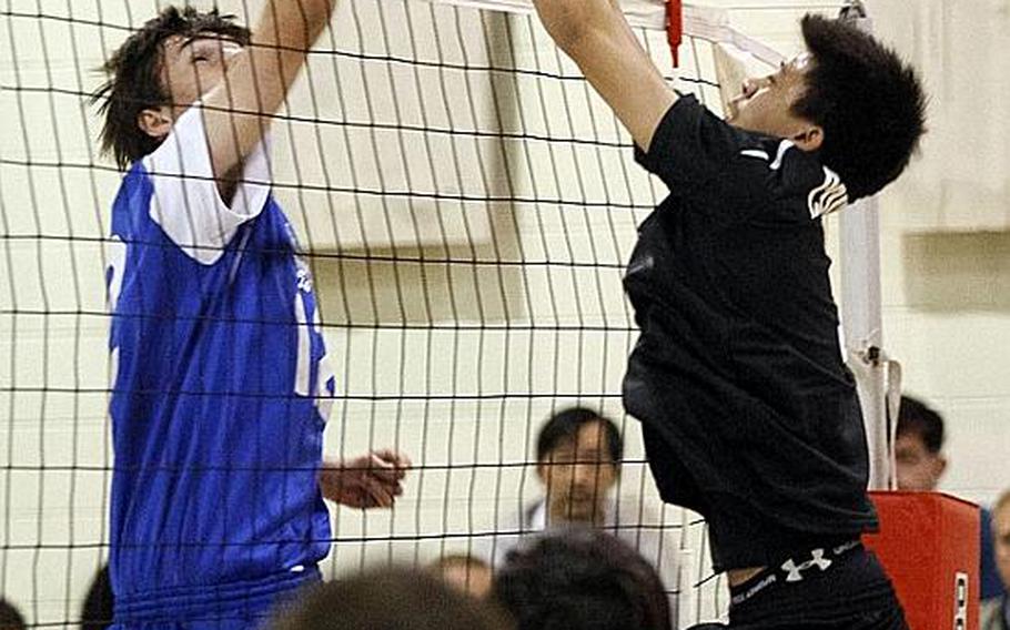 Seoul American setter Eric Tarikas, left, and Osan American setter Nathan Baldevia battle for the ball at the net during Friday's Korean-American Interscholastic Activities Conference boys volleyball match at Cougars Gymnasium, Osan American High School, Osan Air Base, South Korea. Osan won 25-10, 21-25, 25-17, 22-25, 15-9 to remain unbeaten through 12 matches in the KAIAC Division I season. The Cougars are going for a school-first unbeaten season and KAIAC regular-season and tournament title.