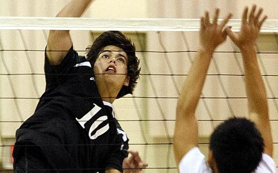 Osan American's Billy Bortscheller, left, tries to hit the ball past Josh Chung of Seoul American during Friday's Korean-American Interscholastic Activities Conference boys volleyball match at Cougars Gymnasium, Osan American High School, Osan Air Base, South Korea. Osan won 25-10, 21-25, 25-17, 22-25, 15-9 to remain unbeaten through 12 matches in the KAIAC Division I season. The Cougars are going for a school-first unbeaten season and KAIAC regular-season and tournament title.