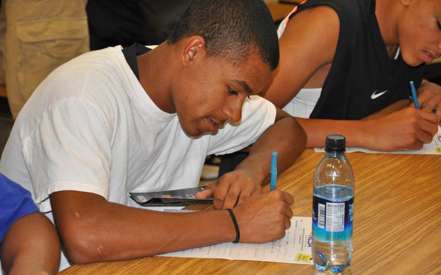 Bamberg junior Tyler Lewis fills out a National Collegiate Scouting Association recruiting form at the Bamberg High School gym. Lewis was one of about 50  Bamberg student-athletes who attended a seminar led by former professional football player Derrick Mayes called ''College Recruiting Simplified.'' Mayes presented similar seminars at several high schools during a three-day visit to Europe.