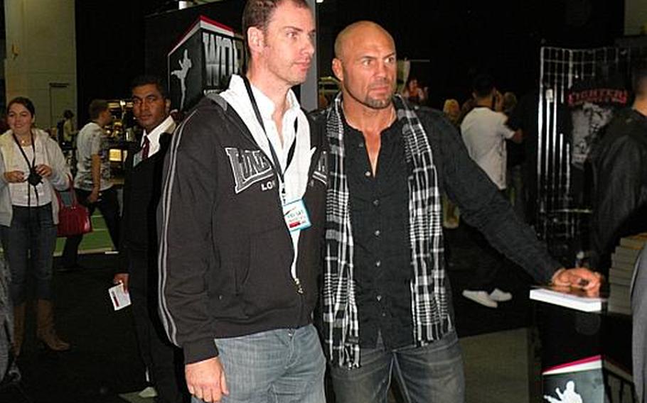 Ultimate Fighting Championship legend Randy ''The Natural'' Couture, right,  poses with a fan during the UFC Fan Expo held at the Earls Court Exhibition Center in London, Oct. 15-16.