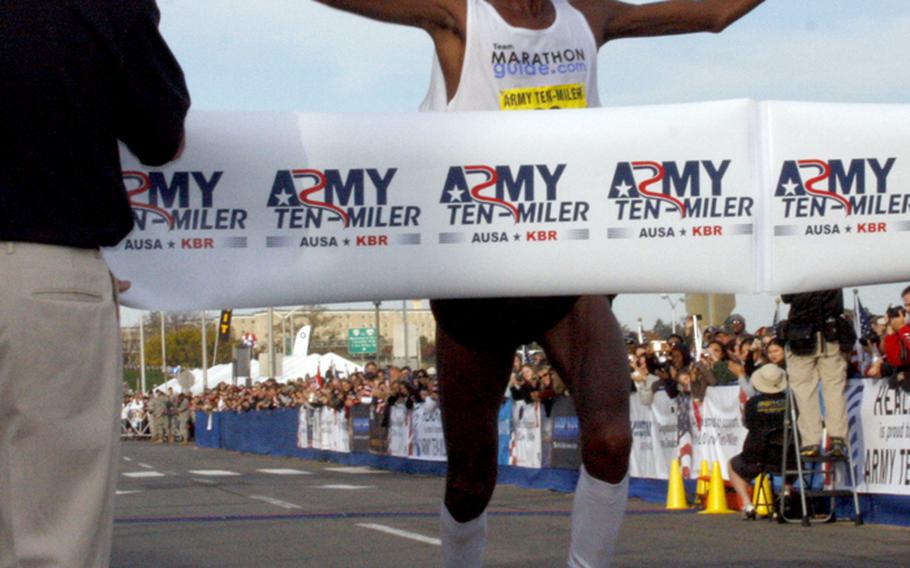 Alene Reta, a native of Ethiopia now living in Manhattan, crosses the finish line as the winner of the Army 10 Miler for the second year in a row. Holding the finish tape at left is Army Chief of Staff Gen. George Casey.