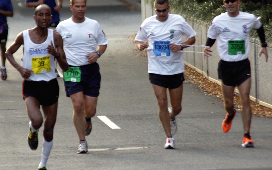 Eventual winner Alene Reta, left, passes Capt. Ivan Castro, second from right, and his running partners during Sunday's Army 10 Miler on the streets of Washington. Running with Castro, who was blinded in combat in Iraq in September, 2006, are his friend Staff Sgt. Ruben Hernandez, right, and his commanding officer, Lt. Col. Jeffrey Bryan of the Special Operations Recruiting Battalion at Fort Bragg, N.C. Castro, who will also run in next week's Marine Corps Marathon, finished in 1:25:44.