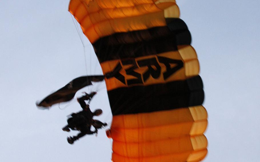 A parachutist from the Army's Golden Knights descends toward the starting area.