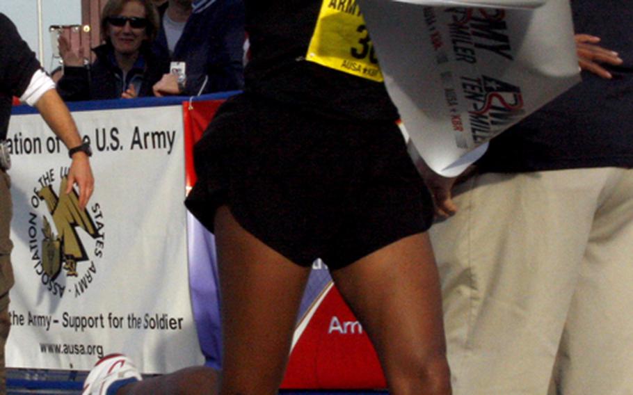 Aziza Abate of Ellicott City, Md., breaks the tape to win the women's race in a time of 55:54.