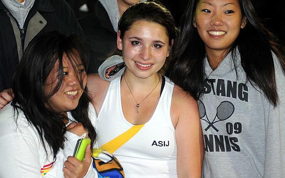 A teary-eyed singles champion Kelsey Leon is flanked by teammates and repeat doubles champions Saaya Imura and Nicole Cho after Wednesday's Kanto Plain Association of Secondary Schools tennis tournament at Shirako Tennis Club, Shirako, Chiba Prefecture, Japan. Leon beat Yokota's Erika Ettl 6-2, 6-4 for the singles crown; Cho and Imura beat Christian Academy Japan's Hanna Mori and Hana Yamanaka 6-1, 6-3 for the doubles.