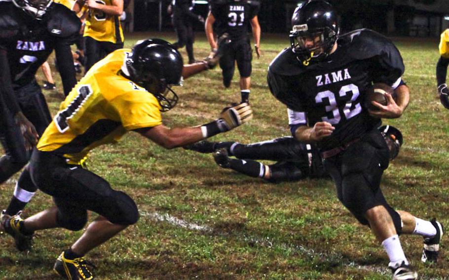 Zama American running back Michael Spencer seeks running room against Joey Ferrere of American School In Japan during Friday's Kanto Plain Association of Secondary Schools football game at Trojans Field, Zama American High School, Camp Zama, Japan. Zama won, 27-9.