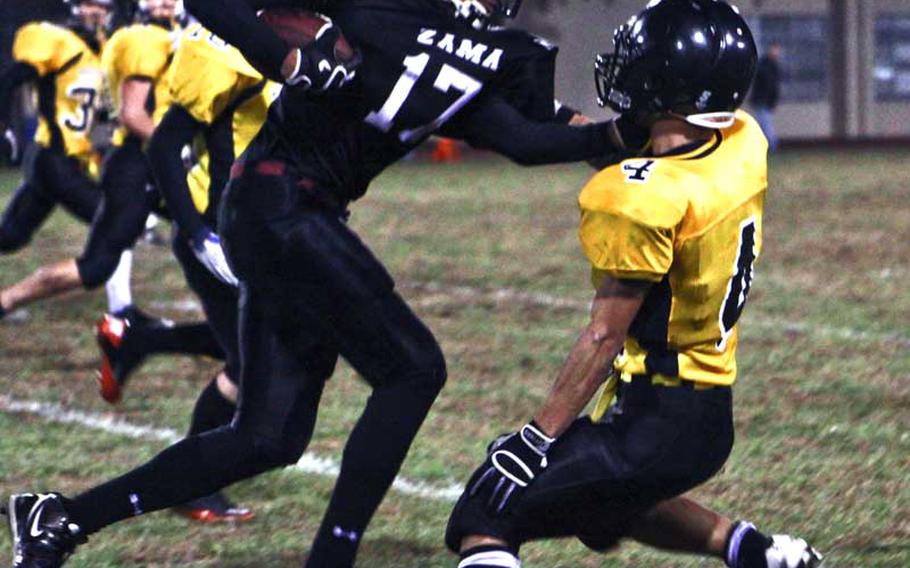 Zama American running back Mitchell Harrison seeks running room against Charlie Seno of American School In Japan during Friday's Kanto Plain Association of Secondary Schools football game at Trojans Field, Zama American High School, Camp Zama, Japan. Zama won, 27-9.