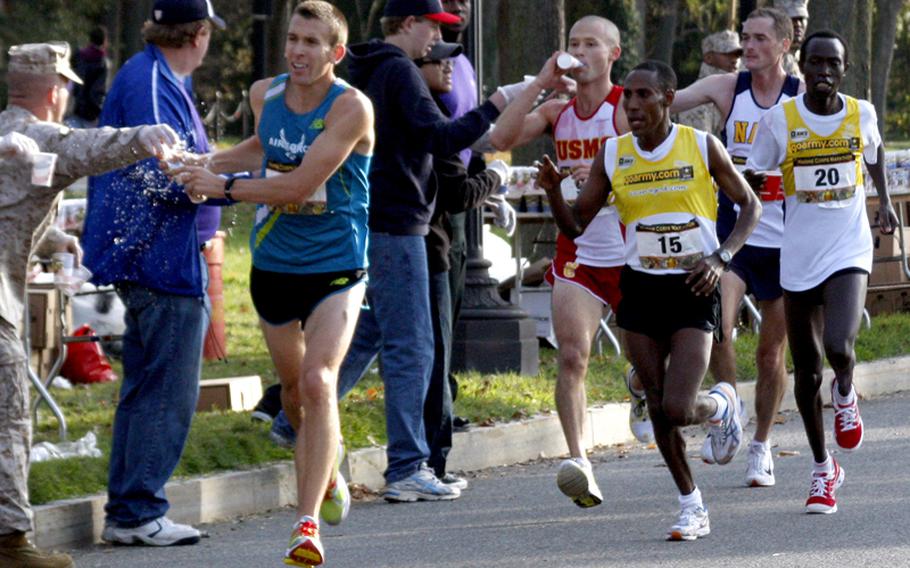 The lead runners grab a drink as they approach the 16-mile mark near the Lincoln Memorial. At left is Air Force 2nd Lt. Jacob Bradosky, the eventual winner; second place went to Ronald Kurui (20) and third went to Marine Corps 1st Lt. Sean Barrett (second from left).