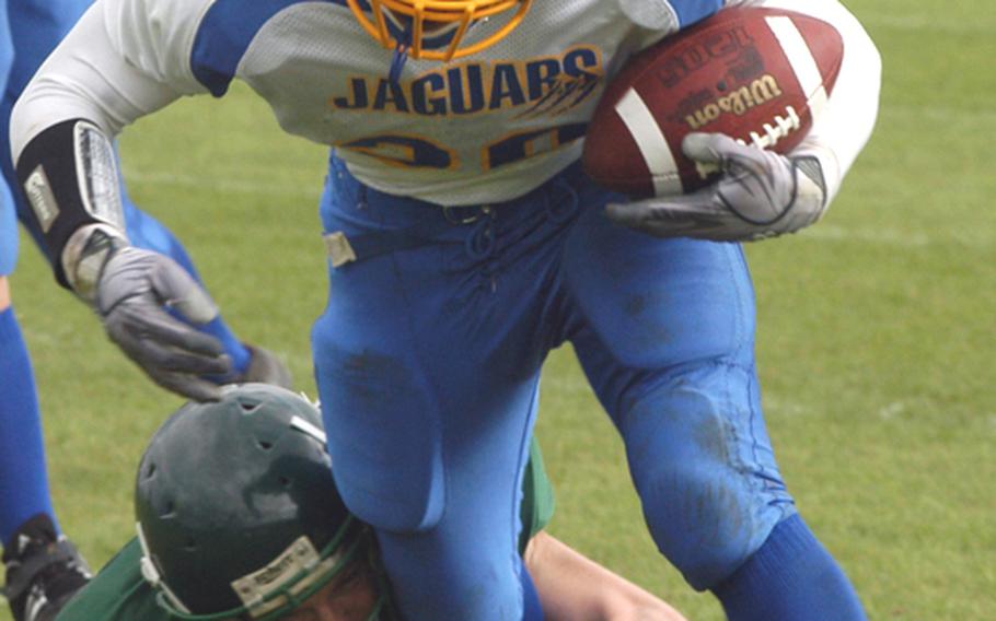 Sigonella running back Jeff Lastrella sheds a tackle attempt by linebacker Beau Hocevar on his way to a first down.Alconbury won the game, 26-20, in double overtime on Sept. 25, but later forfeited by the Dragons for using an ineligible player. The two teams meet again in the Division III championship game.