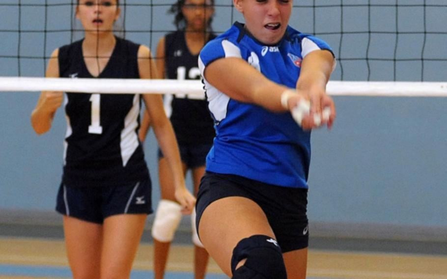 Milan's Veronica Spagnoli makes a running, back-to-the-net return of a Bitburg shot in Milan's three-set win over the Barons in Division II action Thursday at the DODDS-Europe volleyball championships on Thursday. Watching the action at left is Bitburg's Jade Robbins.